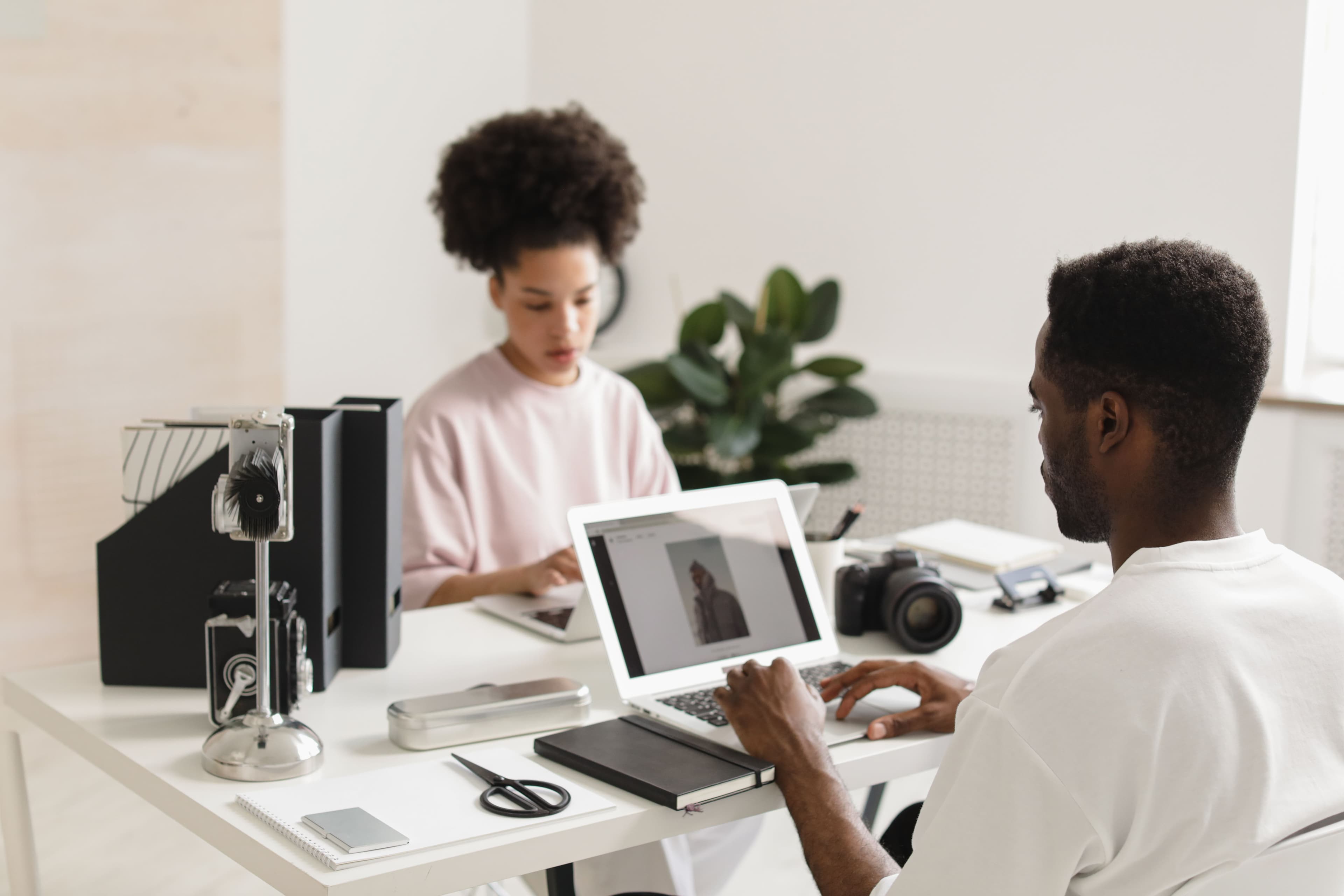 Two creatives reviewing a client photo on a laptop in a studio
